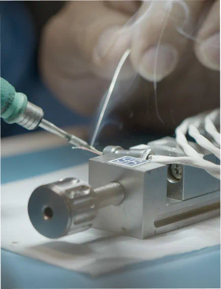 Close-up of hands working on precision manufacturing assembly